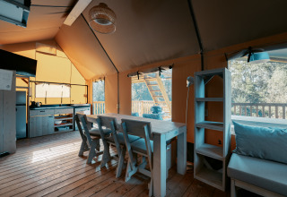 Interiør af Ranger Lodge ved Camping de Italiaanse Meren i Holland med spisebord og køkkenfaciliteter.