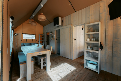 Innenaufnahme der Ranger Lodge auf Camping de Italiaanse Meren in den Niederlanden mit Holzmöbeln.