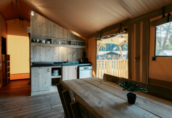 Interieur van Safari Lodge XL tent met houten meubels en keuken op Camping de Italiaanse Meren, Nederland.