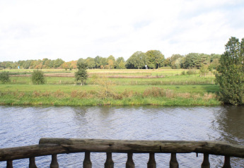Vista dalla casa sull'albero Ooievaarsnest sul fiume e campi di Camping de Koeksebelt, Paesi Bassi.