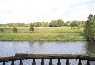 Vista dalla casa sull'albero Ooievaarsnest sul fiume e campi di Camping de Koeksebelt, Paesi Bassi.