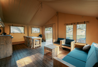 Interieur van de ruime Nomad XL safaritent bij Camping de Italiaanse Meren in Nederland met houten meubels.