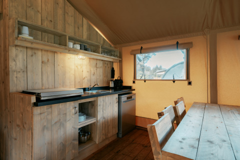 Cocina y comedor dentro de la tienda safari Nomad XL en Camping de Italiaanse Meren, Países Bajos.