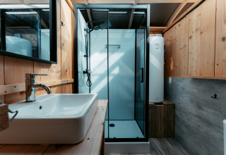 Salle de bain moderne avec douche vitrée et bois à Panorama, Camping de Italiaanse Meren, Pays-Bas.