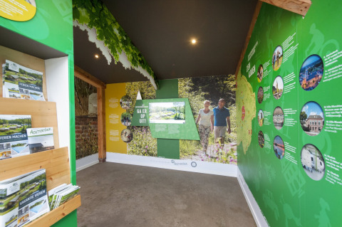 Centro de información en Camping de Italiaanse Meren, Gelderland, Países Bajos, con folletos y murales verdes.