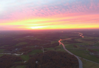 Solnedgang udsigt fra Ooievaarsnest træhus ved Camping de Koeksebelt i Holland med flod og landskab.
