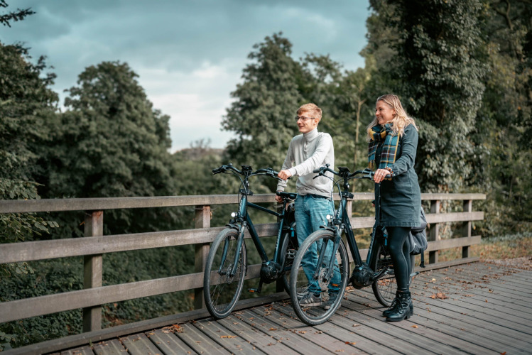 Deux personnes font une pause avec leurs vélos sur un pont de Camping de Italiaanse Meren, en Gelderland.