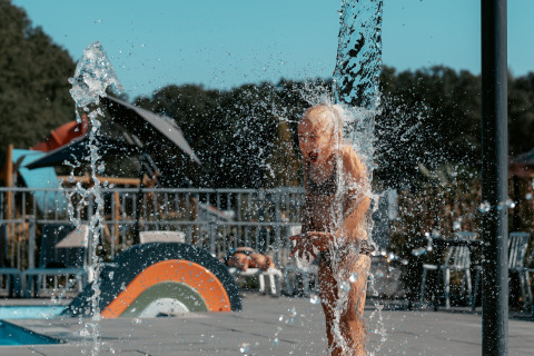 Un bambino gioca tra gli spruzzi d'acqua al Camping de Italiaanse Meren, un villaggio vacanze in Gheldria, Paesi Bassi.