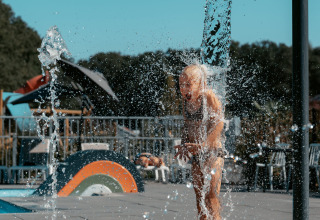 Ein Kind spielt mit Wasserfontänen im Camping de Italiaanse Meren, einem Ferienpark in Gelderland, Niederlande.