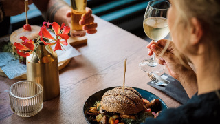 Dos personas disfrutan de hamburguesas y vino en Camping de Italiaanse Meren, Gelderland, Países Bajos.