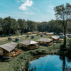 View of Camping de Italiaanse Meren holiday park in Gelderland, Netherlands, with tents and a pond.