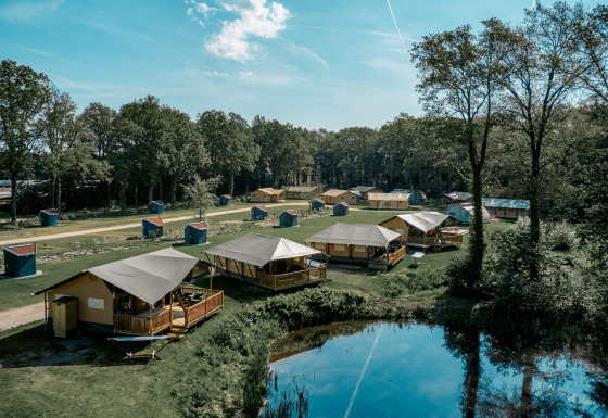 Zicht op Camping de Italiaanse Meren, vakantiepark in Gelderland, Nederland, met tenten rond een vijver.