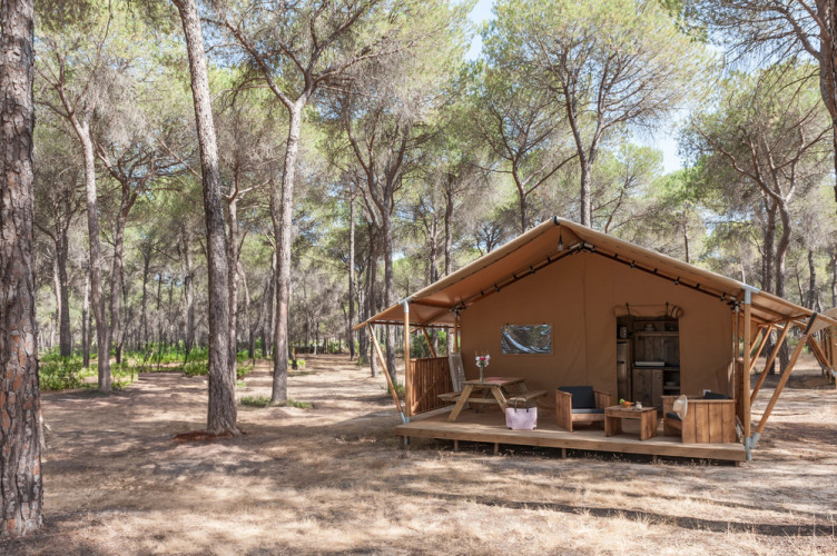Una cómoda tienda de glamping en el bosque en Huttopia Parque de Doñana, un parque vacacional en Andalucía.