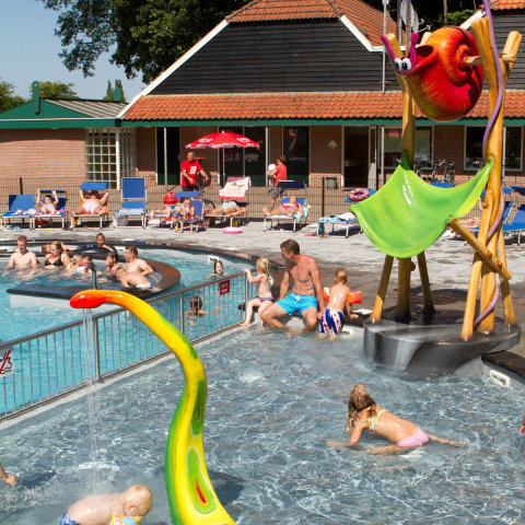 Niños y adultos disfrutan de la piscina en Camping de Koeksebelt, Países Bajos, en un día soleado.