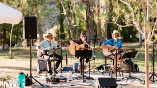 Banda en vivo actuando al aire libre entre árboles en Huttopia Parque de Doñana, Andalucía, España.