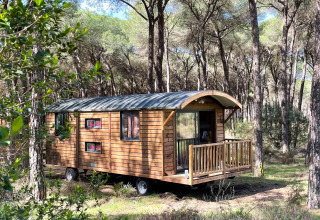 Houten woonwagen in het bos bij Huttopia Parque de Doñana, een vakantiepark in Andalusië, Spanje.