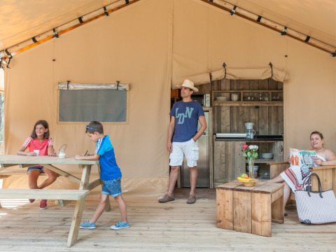 Familia disfruta en una tienda glamping en Huttopia Parque de Doñana, Andalucía, España.