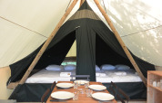 Intérieur d’une tente safari Canadienne avec des lits et une table à Huttopia Parque de Doñana, Espagne.