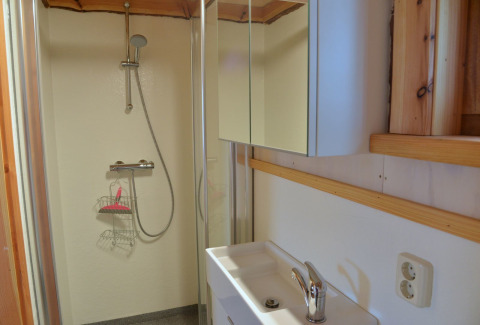 Bagno con doccia e mobile a specchio nella casa sull’albero Ooievaarsnest al Camping de Koeksebelt, Paesi Bassi.