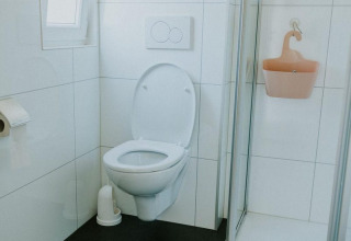 Salle de bains moderne avec toilettes suspendues et douche à Forest Lodge, Camping Si-Es-An, Pays-Bas.