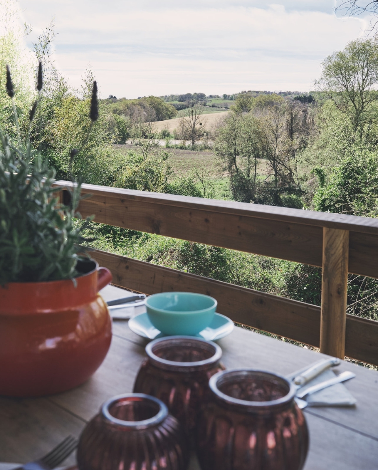 Uitzicht vanaf een safaritent bij Camping d'Artagnan in Frankrijk met gedekte tafel en groen landschap.