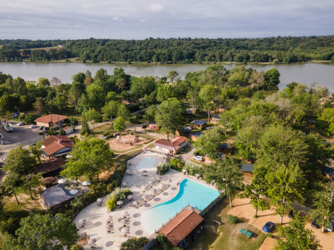 Vista aérea del camping Huttopia Lac de l'Uby - Gers con piscina, lago y áreas verdes en Occitanie, Francia.