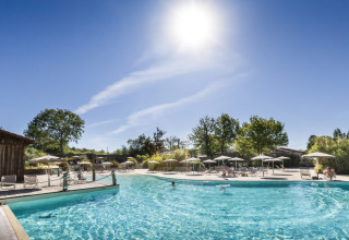 Buitenzwembad bij Huttopia Lac de l'Uby - Gers vakantiepark in Occitanië, Frankrijk, onder een stralende zon.
