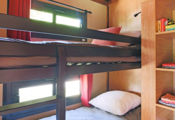 Zona notte con letti a castello e finestre nella Gypsy caravan al Camping Valkenburg - Maastricht, Paesi Bassi.