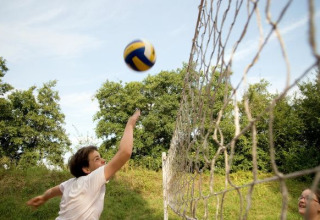 Adolescentes juegan voleibol al aire libre en Camping Valkenburg - Maastricht, parque vacacional en Limburg, Países Bajos.