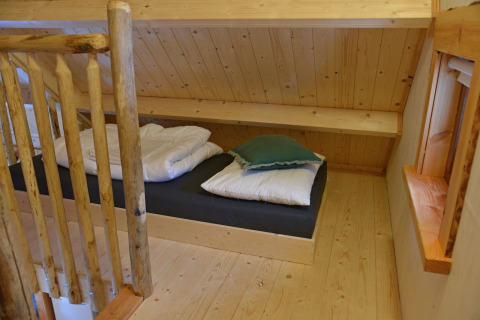Coin nuit douillet dans la cabane Ooievaarsnest du Camping de Koeksebelt, Pays-Bas, décor bois.