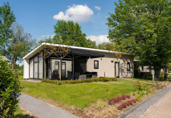 Moderna Bos Lodge presso Holiday Resort 't Schuttenbelt in Olanda, circondata da alberi e giardino verde.