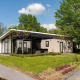 Moderne Bos Lodge på Holiday Resort 't Schuttenbelt i Holland, omgivet af grønne træer og have.