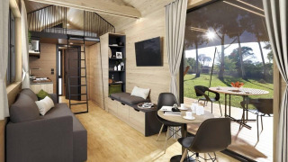 Acogedora casa pequeña con sofá, comedor, altillo y gran ventana con vistas al jardín en Bélgica.