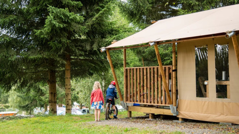 Due bambini giocano fuori dalla tenda safari Comet al campeggio Petite Suisse in Belgio.