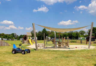 Aire de jeux avec toboggan, kart à pédales et voile d'ombre au Camping Dal van de Mosbeek, Overijssel.