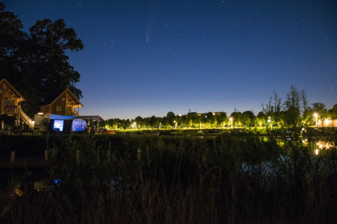 Photo de nuit de la cabane dans les arbres au Camping de Koeksebelt aux Pays-Bas, reflets nocturnes.