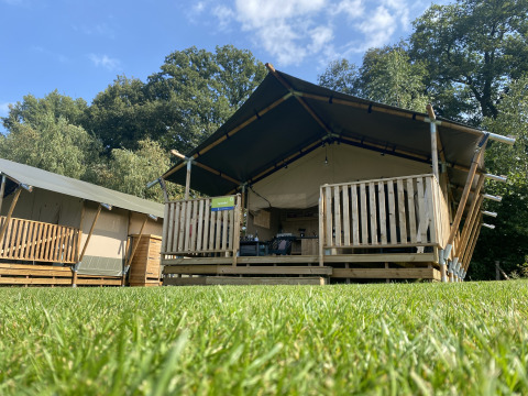 Safari-telt med eget bad på Camping Dal van de Mosbeek i Holland, set fra den grønne plæne.