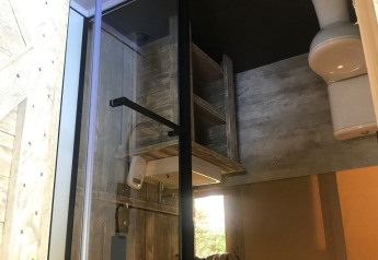 Innenansicht eines Badezimmers im Safari-Zelt auf Camping Dal van de Mosbeek, mit Dusche und Toilette.