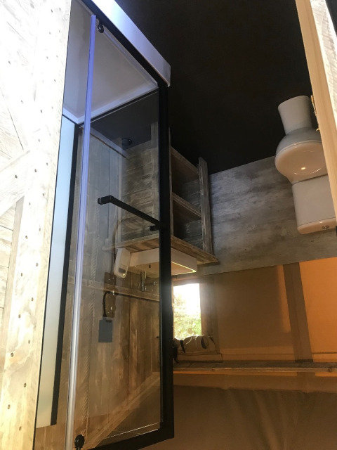 Interieur van een badkamer in een safaritent op Camping Dal van de Mosbeek, met douchecabine en toilet.