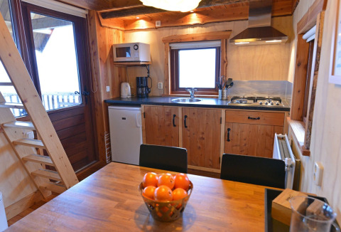 Moderne Küche und Essbereich im Baumhaus bei Camping de Koeksebelt, Niederlande, mit Obstschale.