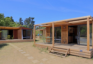 Houten chalets met terrassen op Camping d'Angers - Lac de Maine, Centre-Val de Loire, Frankrijk, zonnige dag.