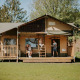 Familie nyder ophold i Ranger lodge på Camping Si-Es-An i Holland, omgivet af natur og træer.