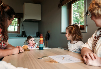 Gezin aan tafel in de Wellness lodge bij Ackerlodges Ruinerwold BV in Nederland, met kinderen aanwezig.