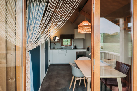 Lodge bien-être moderne à Ackerlodges Ruinerwold BV, Pays-Bas, avec cuisine et coin repas chaleureux.