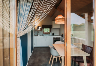 Lodge de bienestar en Ackerlodges Ruinerwold BV, Países Bajos, con cocina moderna y zona de comedor acogedora.