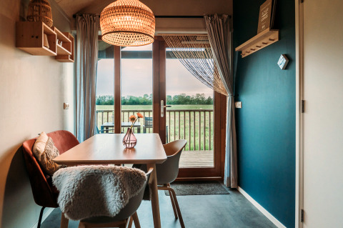 Cozy dining area with rustic decor at the Wellness lodge in Ackerlodges Ruinerwold BV, Netherlands.