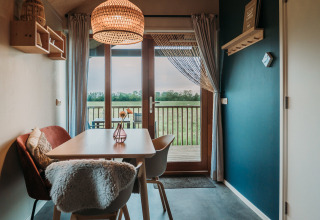 Moderne spiseplads med udsigt til mark fra Wellness lodge på Ackerlodges Ruinerwold BV, Holland.