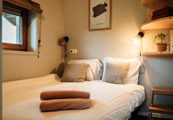 Gezellige slaapkamer met dubbel bed, zachte kussens en warme verlichting bij Wellness lodge Ackerlodges Ruinerwold BV.
