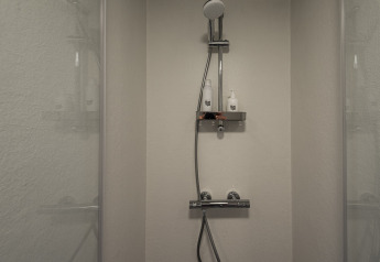 Moderne douche bij Wellness Lodge, Ackerlodges Ruinerwold BV, Nederland, met twee flessen op de plank.