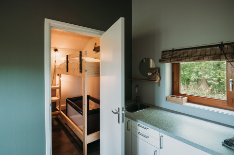 Moderne lodgeinteriør med køkken og køjeseng på Wellness lodge hos Ackerlodges Ruinerwold BV, Holland.